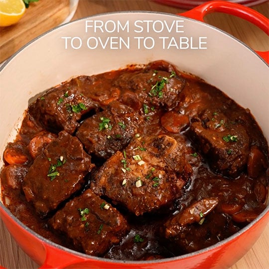 wide dutch oven filled with a large amount of meat to show the capacity under text that reads: from stove to oven to table
