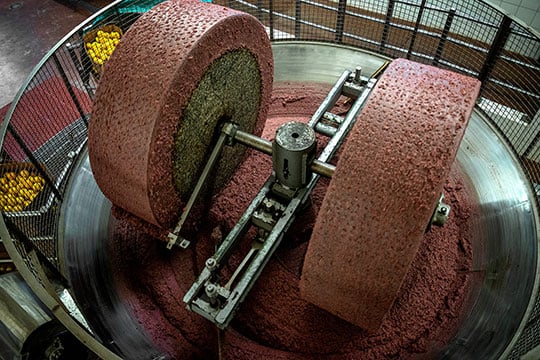 two large wheels on a rotor crush olives