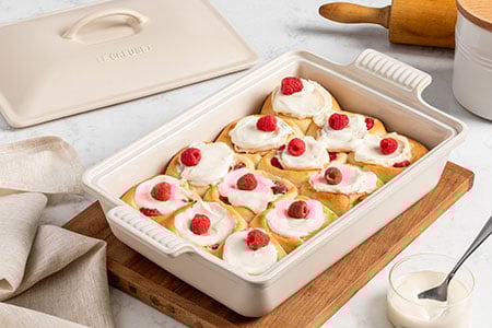 sweet rolls topped with dollops of whipped cream and cherries