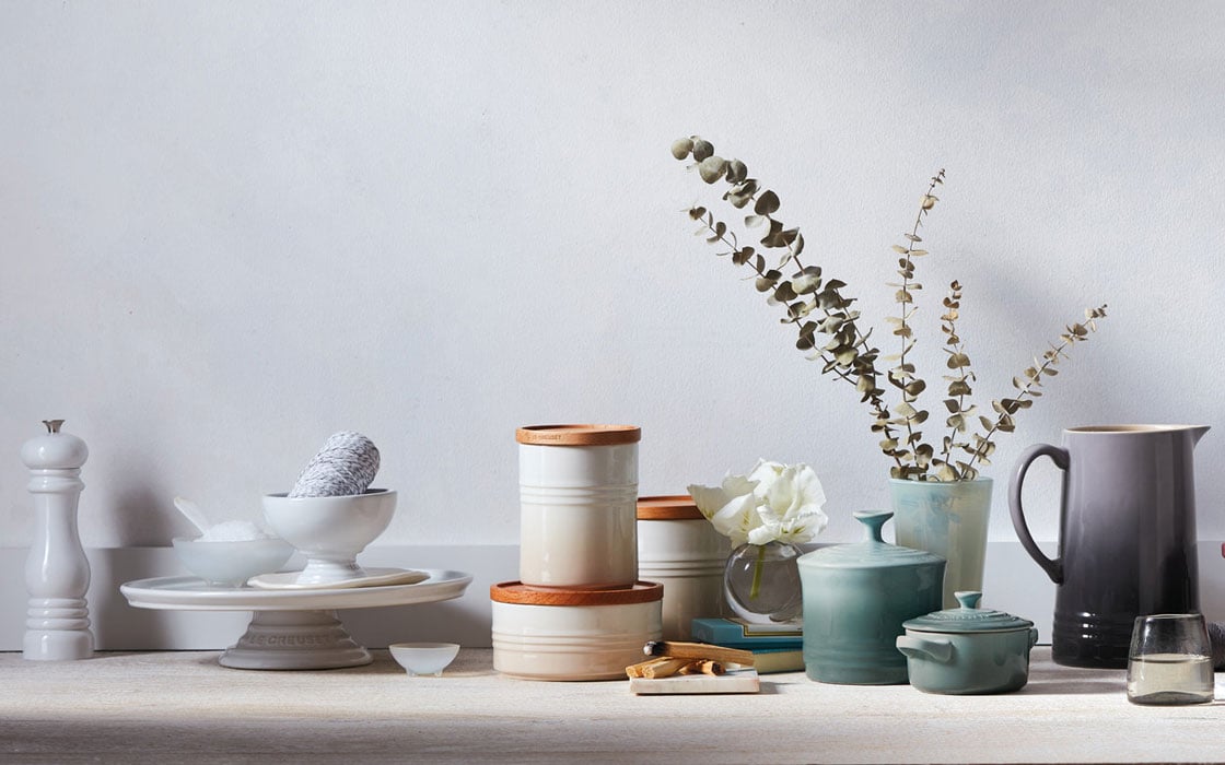neutral stoneware items on a countertop with home decor