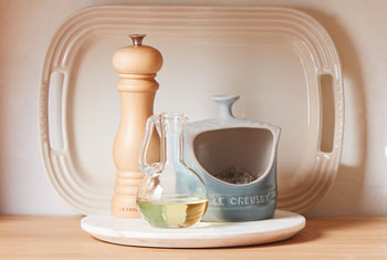 light blue salt crock next to a wooden pepper mill