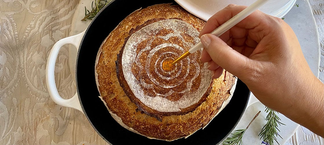 painting a round loaf of bread with food coloring