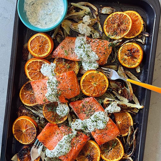 salmon with oranges and onion on a sheet pan