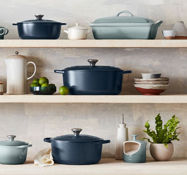 shelves of matte navy cookware paired with flame orange cookware