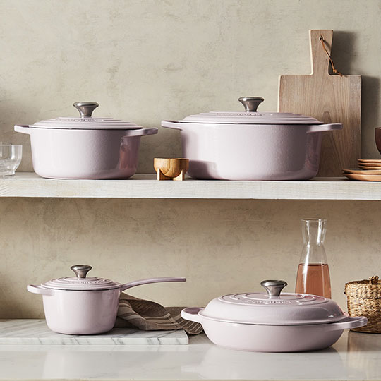 light pink cookware against a light wood background