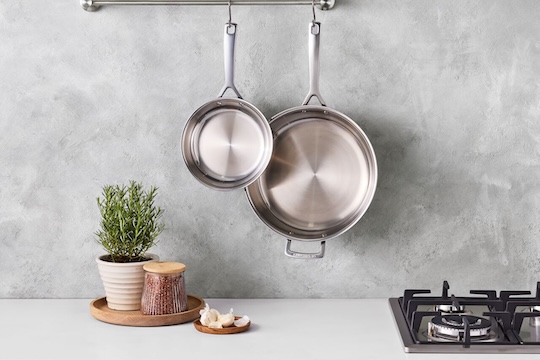 stainless fry pans hanging on hooks