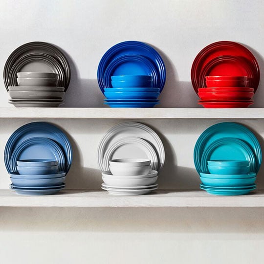 stacks of colorful dinnerware on shelves