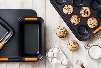 muffins in a mini muffin pan surrounded by non-stick metal bakeware