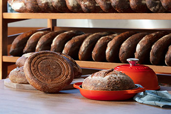 flame orange bread oven surrounded by loaves of freshly baked bread