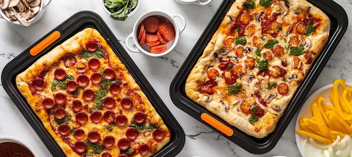 two rectangular pizzas baked on non-stick sheet pans