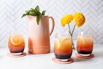 cocktails served from a peach-colored stoneware pitcher