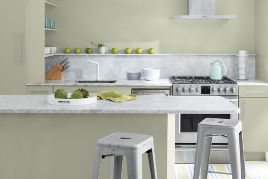 minimalist modern kitchen with marble counters and light sage green walls