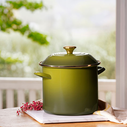 green stockpot with gold knob on a counter