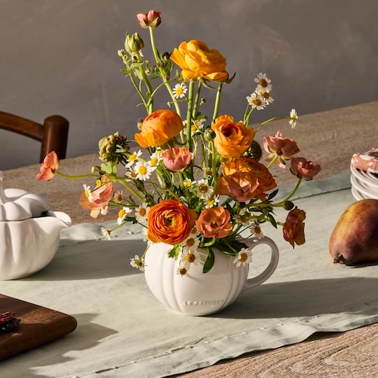 flower arrangement in a pumpkin shaped dish