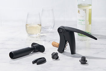 Wine tools and glasses alongside a white wine bottle