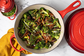beef and broccoli in a red cassadou