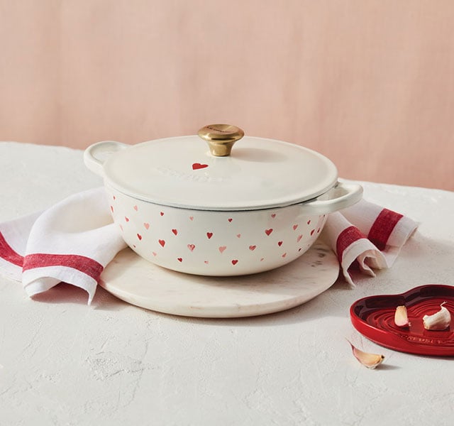 white dutch oven adorned with little red and pink hearts
