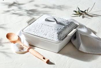 square white covered casserole with olive branch design embossed on the lid