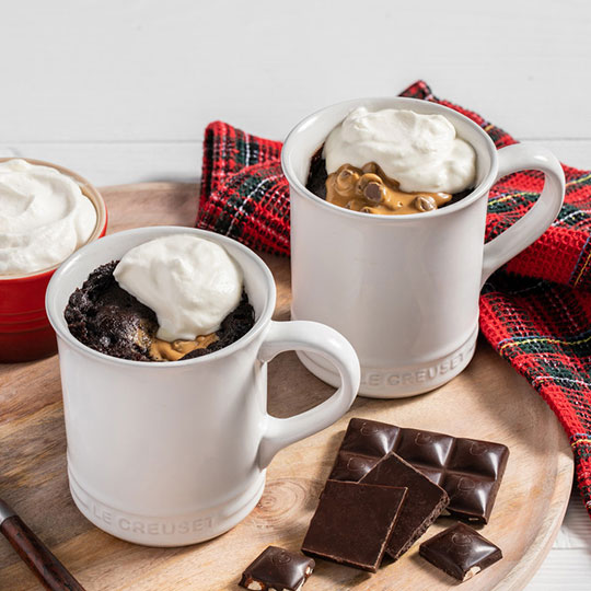 mugs of chocolate cake with peanut butter and whipped cream