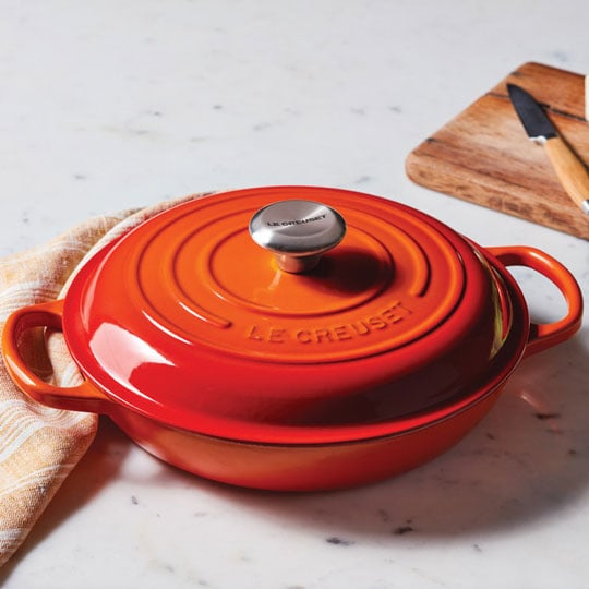 flame orange cast iron braiser on a countertop