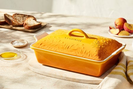 rectangular yellow covered casserole with olive branch design embossed on the lid
