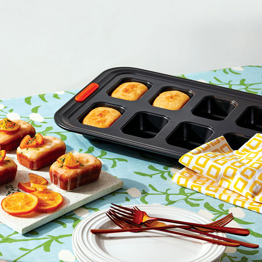 non-stick mini loaf pan beside iced and decorated mini loaves