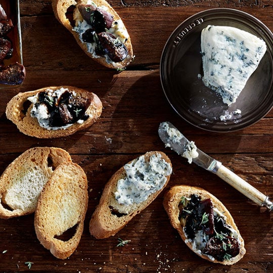 rustic image of blue cheese with chopped figs and sprigs of thyme on baguette rounds