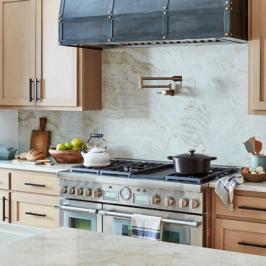 farmhouse inspired kitchen with wood cabinets and stainless appliances