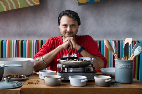 Chef Chintan Pandya at a table surrounded by cookware