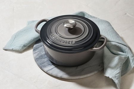oyster gray dutch oven with light green kitchen towel