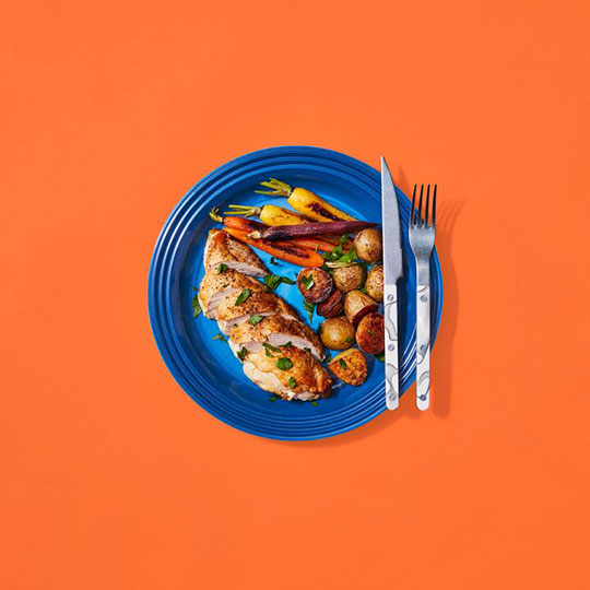 roast chicken and veggies on a blue plate