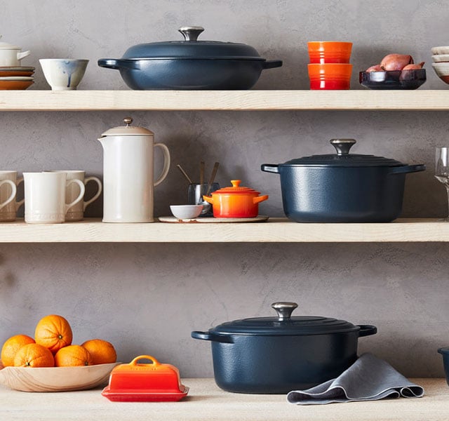 shelves of matte navy cookware paired with flame orange cookware