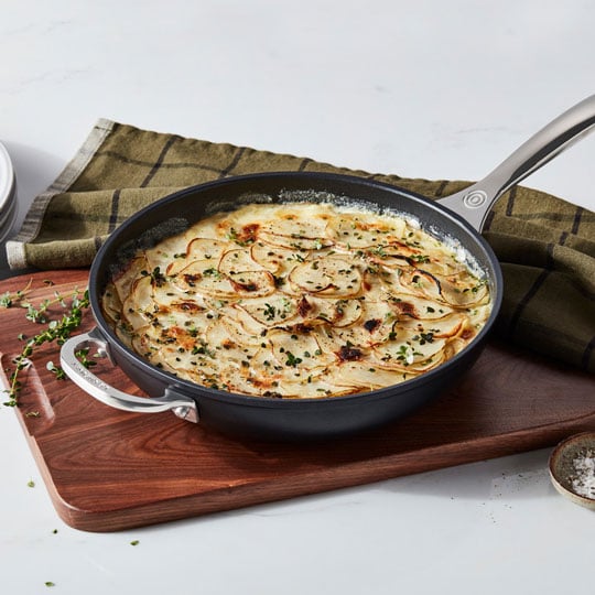 non-stick fry pan filled with scalloped potatoes