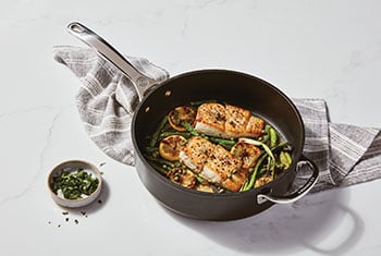 fish filets and veggies in a non-stick fry pan
