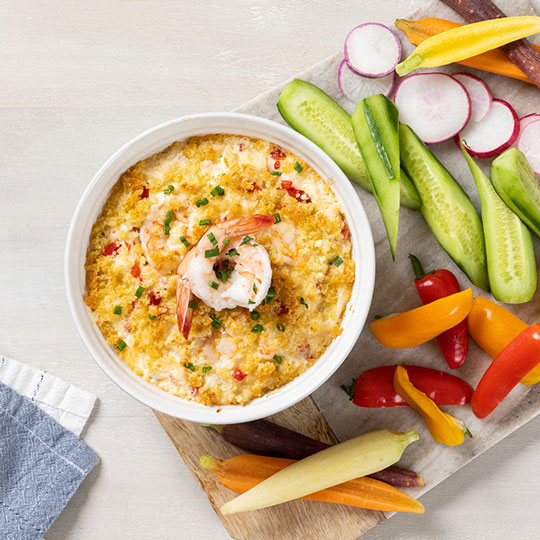 a bowl of baked shrimp dip with vegetable crudite