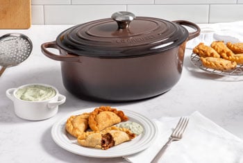 empenadas next to a brown dutch oven