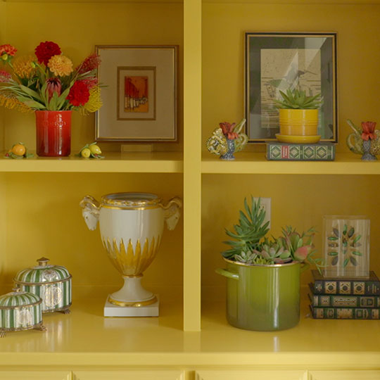 boldly colored items on shelves set against a yellow background