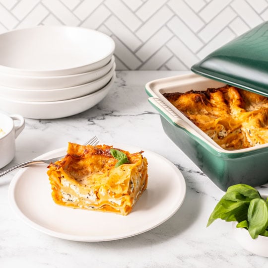 lasagna in a green covered baker