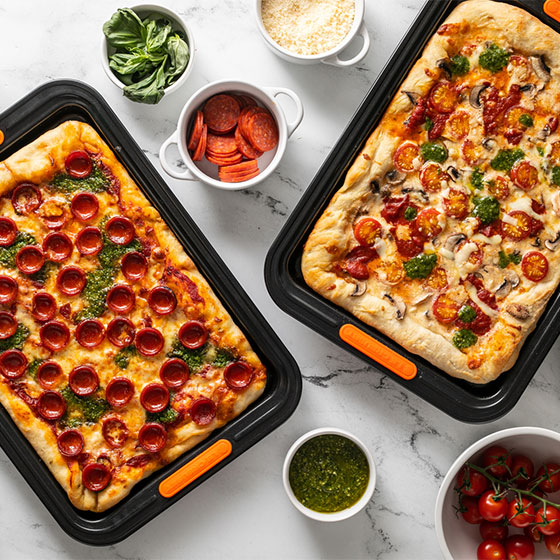 two rectangular pizzas on sheet pans