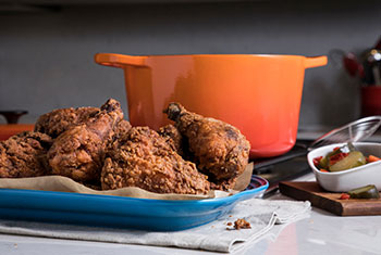 crispy fried chicken in front of a flame deep dutch oven