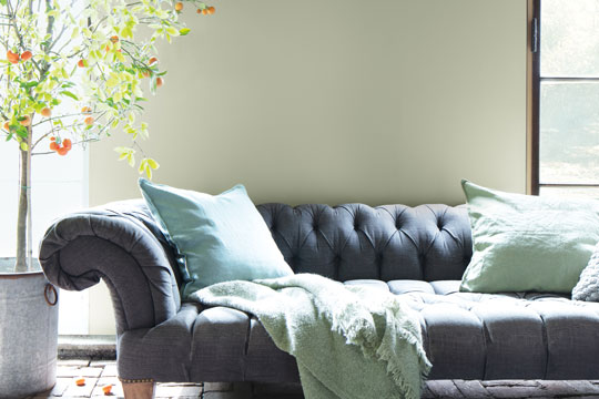 gray couch with light sage green textiles and pillows