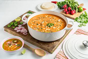 creamy tomato based soup in a wide dutch oven