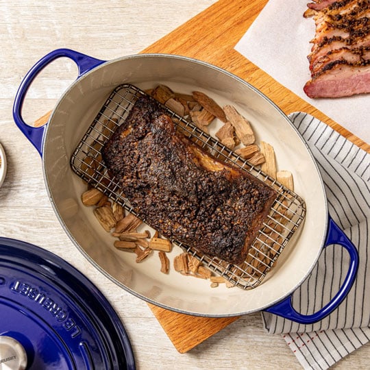smoked meat and wood chips inside a dutch oven