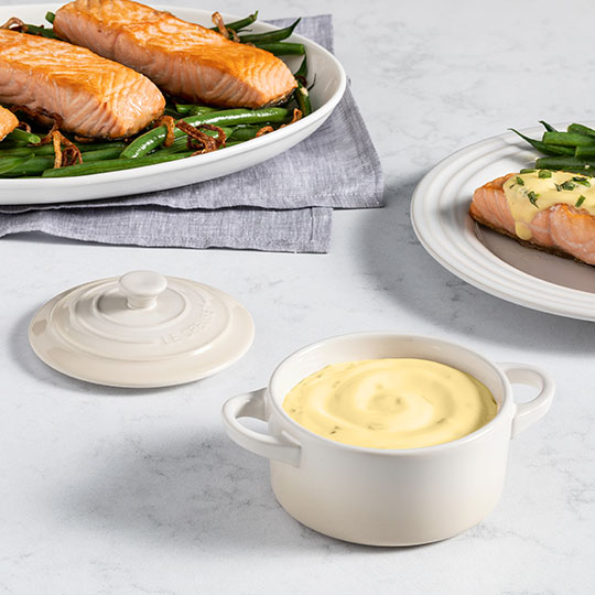 fish filets alongside a mini cocotte filled with creamy sauce