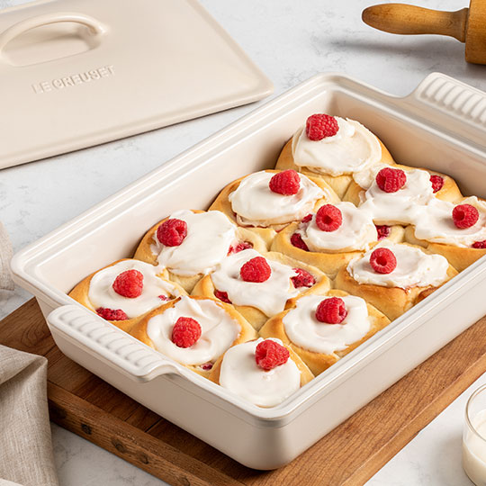 rolls topped with whipped cream and raspberries