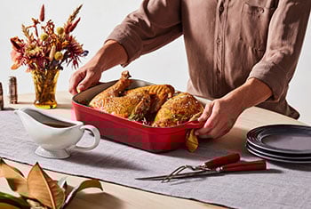 woman setting a turkey on the table