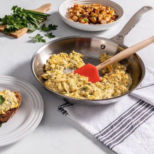eggs cooking in a stainless steel fry pan