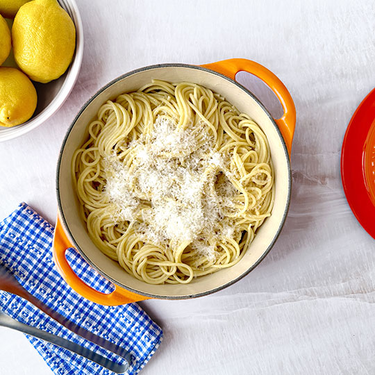 spaghetti next to a bowl of lemons