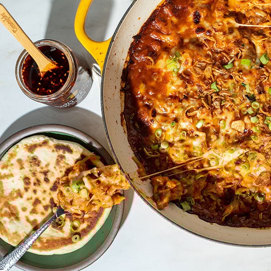 cheesy dip with scallions on top served with flatbread