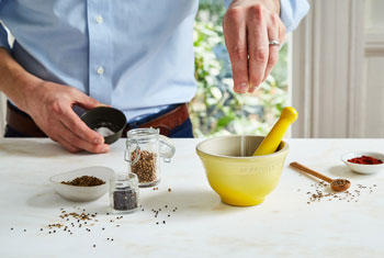 a spice blend is prepared with a stoneware mortar and pestle